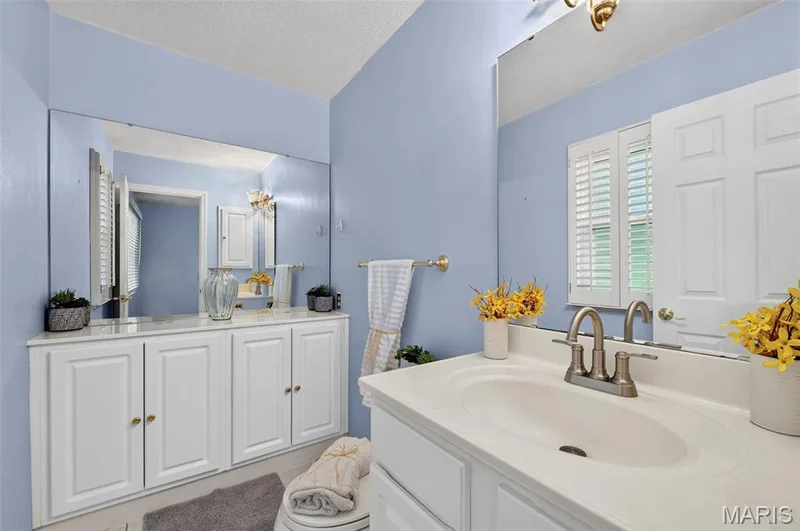 Bathroom featuring a single vanity with an integrated sink, brushed nickel faucet, and white cabinetry — 1319 Brandywine Lane, St Peters, MO 63376