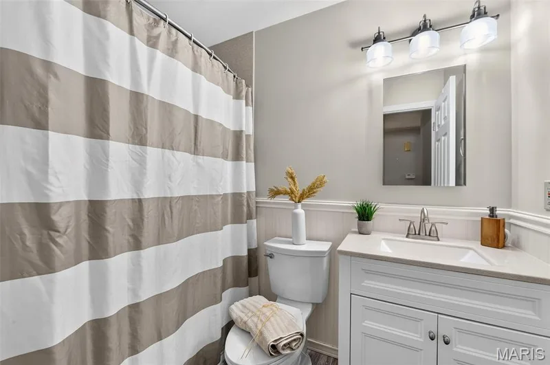 Bathroom featuring a single vanity with stone countertop, white shaker-style cabinetry, and a chrome faucet — 1319 Brandywine Lane, St Peters, MO 63376