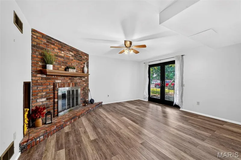 Exposed brick fireplace with a wood mantle and hearth — 1319 Brandywine Lane, St Peters, MO 63376
