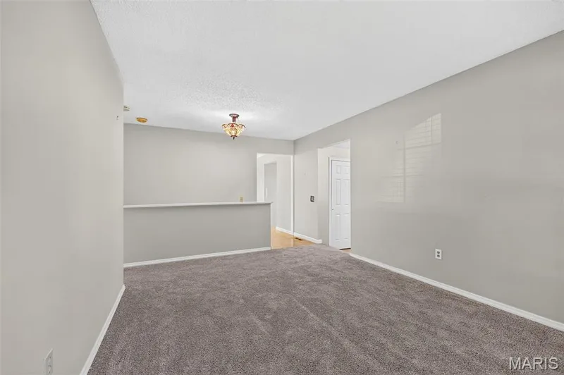 Neutral-toned walls, textured ceiling, and gray carpeting — 1319 Brandywine Lane, St Peters, MO 63376
