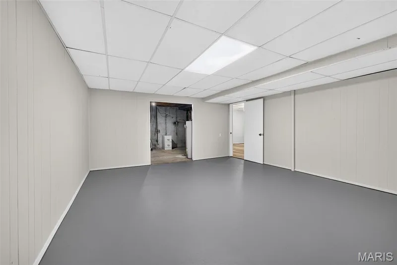 Recessed panel walls, drop ceiling with integrated lighting, resilient flooring, and an interior sliding door — 1319 Brandywine Lane, St Peters, MO 63376