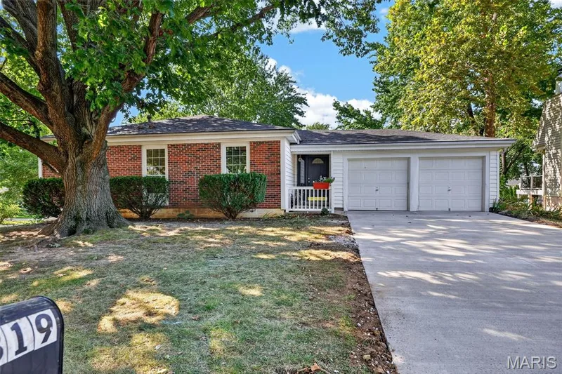 Brick exterior with white trim, a covered porch, a two-car garage, and a concrete driveway — 1319 Brandywine Lane, St Peters, MO 63376