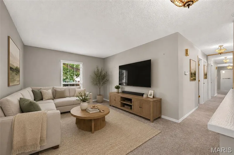 Bright living area featuring a window with natural light, light-toned walls, and carpet flooring — 1319 Brandywine Lane, St Peters, MO 63376
