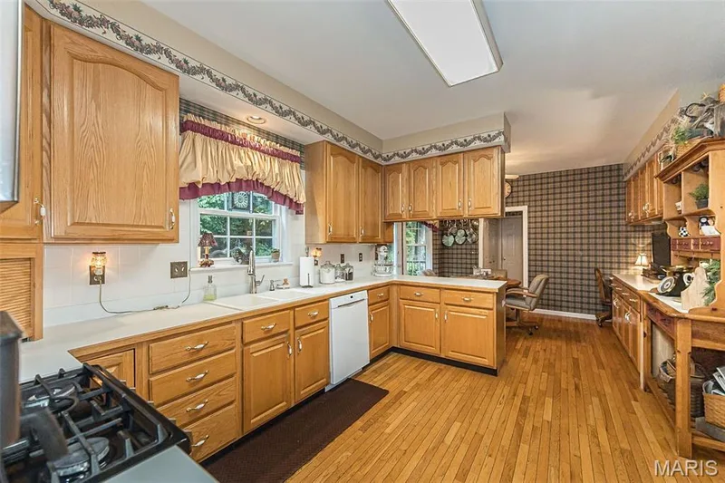 Welcome to the heart of the home! The large kitchen features plenty of cabinet space as well as a breakfast room and desk space. — 868 Natchez Drive, St Charles, MO 63303