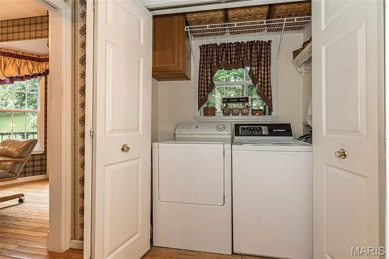Main floor laundry with storage cabinets and hanging. — 868 Natchez Drive, St Charles, MO 63303