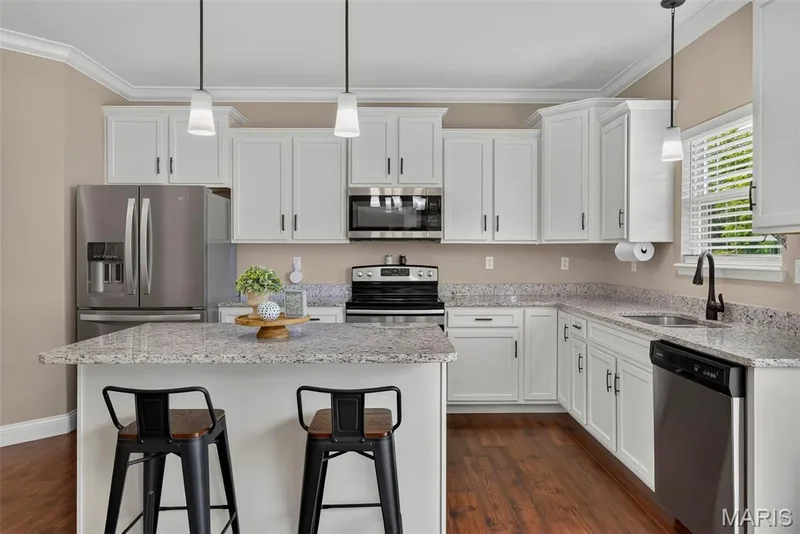 9' ceilings on the rest of the main level.Let's review the Kitchen - Shake style cabinets, crown trim, quartz counters, stainless steel appliances, walk-in pantry and center island — 103 Pomodora Circle, Wentzville, MO 63385