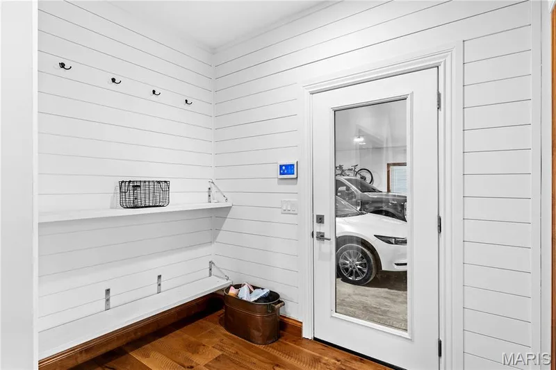 Shiplap wall paneling, rich wood-finish flooring, built-in shelving, and a full-light door — 205 Howell Road, Defiance, MO 63341