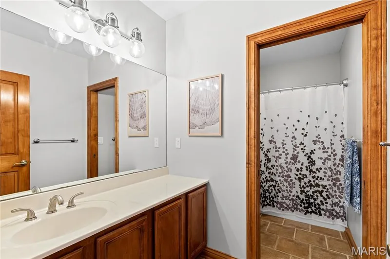 Wood-finish vanity with an integrated sink and brushed nickel faucet — 205 Howell Road, Defiance, MO 63341