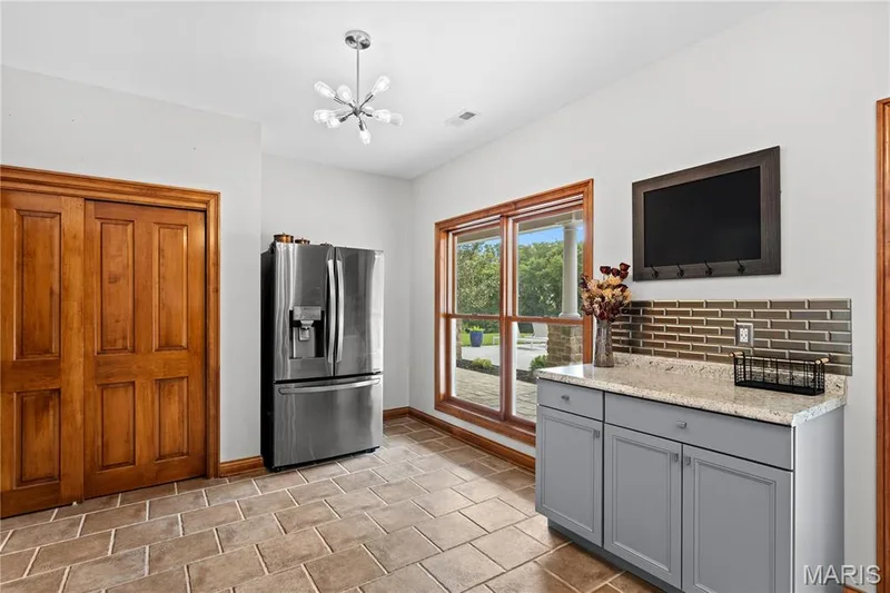 Tiled flooring and a modern Sputnik-style chandelier — 205 Howell Road, Defiance, MO 63341