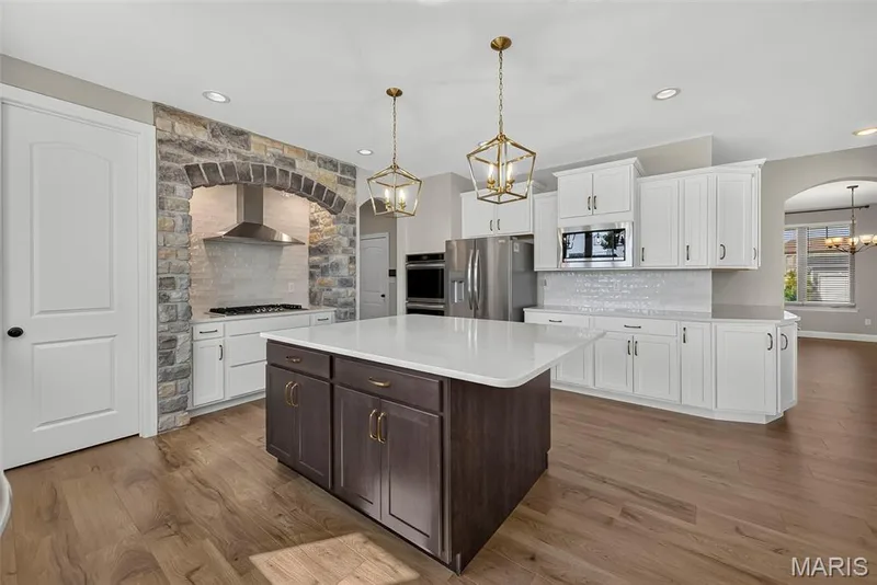 Gourmet Kitchen with Quartz Countertops, Tile Backsplash, Staggered Height Cabinets with Crown Molding and Stainless Steel Applainces — 106 Downview Drive, O'Fallon, MO 63368