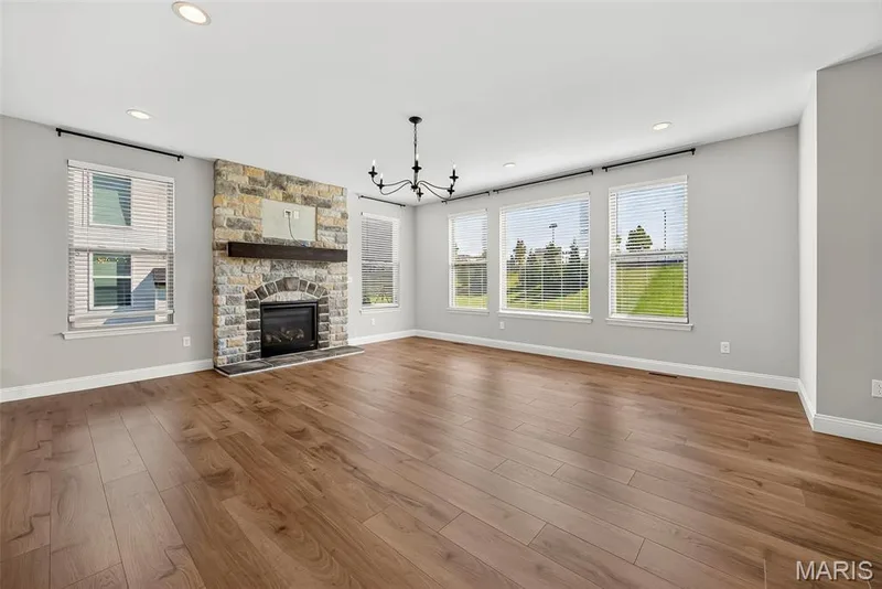 Gas Fireplace with Stone Surround, Window Wall, 9 Foot Ceiling and Luxury Vinyl Plank Flooring in Great Room — 106 Downview Drive, O'Fallon, MO 63368