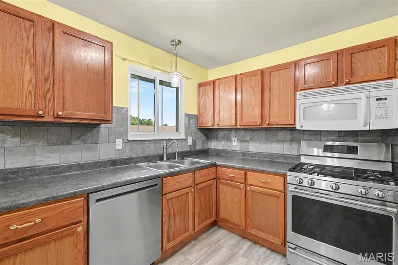 Abundant solid hardwood cabinetry, beautifully understated tile backsplash and another window to the rear yard... — 39 Oxbow Road, St Peters, MO 63376