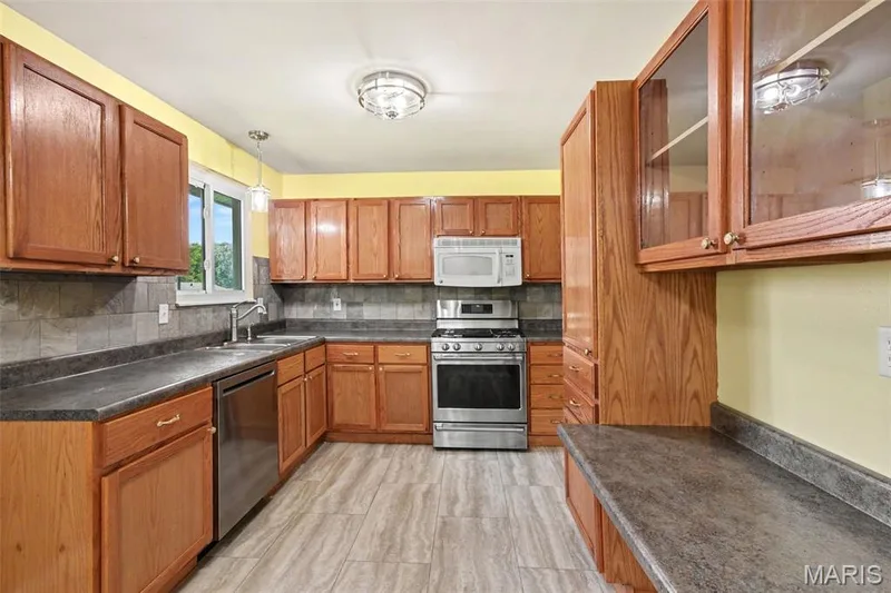 ...with newer appliances, a coffee bar or planning desk below display cabinets and even a pantry to the right of the gas range!! — 39 Oxbow Road, St Peters, MO 63376