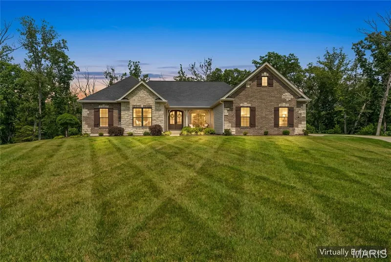 Stone and brick facade with dark wood shutters, front entry with double doors, and established landscaping — 5 Timberdel Place, Foristell, MO 63348