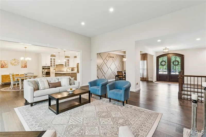 Open-concept living space with dark wood-finish flooring — 5 Timberdel Place, Foristell, MO 63348