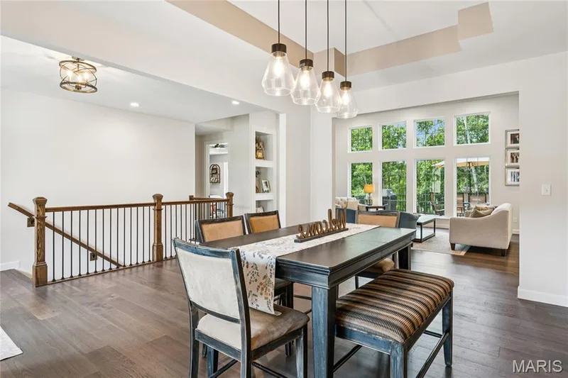 Hardwood flooring, open-concept design, large multi-pane windows, recessed lighting, and a contemporary chandelier — 5 Timberdel Place, Foristell, MO 63348