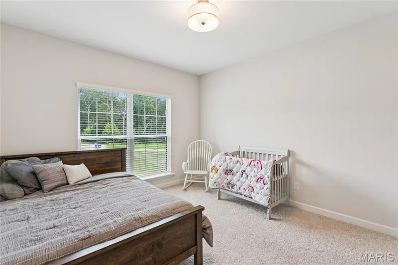 Neutral wall paint, carpet flooring, a multi-pane window with blinds, and a flush mount ceiling light — 5 Timberdel Place, Foristell, MO 63348