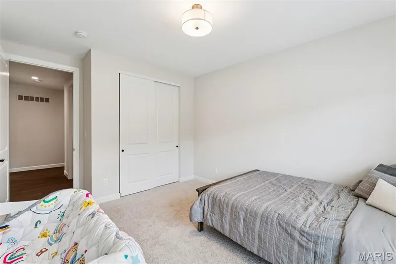 Plush carpeting, ceiling-mounted light fixture, and bifold closet doors — 5 Timberdel Place, Foristell, MO 63348