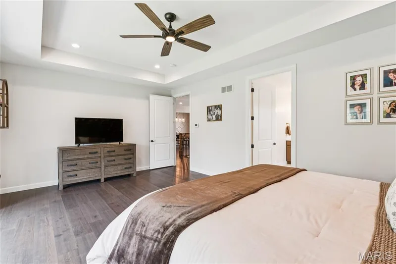 Coffered ceiling with recessed lighting, dark wood-finish flooring, ceiling fan with wood-finish blades, and white interior doors — 5 Timberdel Place, Foristell, MO 63348