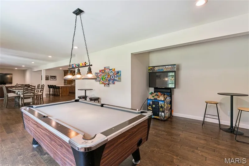 and/or designed for 4th Bedroom, spacious entertainment area featuring luxury vinyl flooring, recessed lighting, and a multi-light pendant fixture — 5 Timberdel Place, Foristell, MO 63348