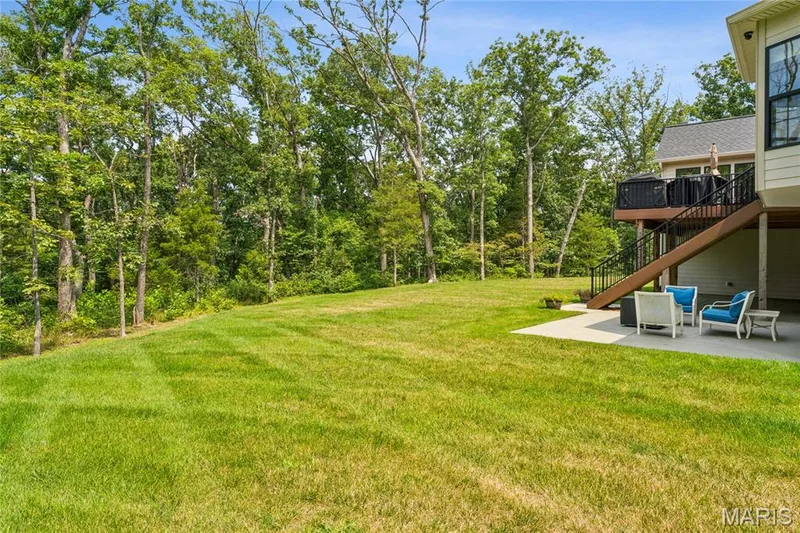 Expansive grassy lawn with mature trees and a concrete patio overlooking beautiful acreage. — 5 Timberdel Place, Foristell, MO 63348
