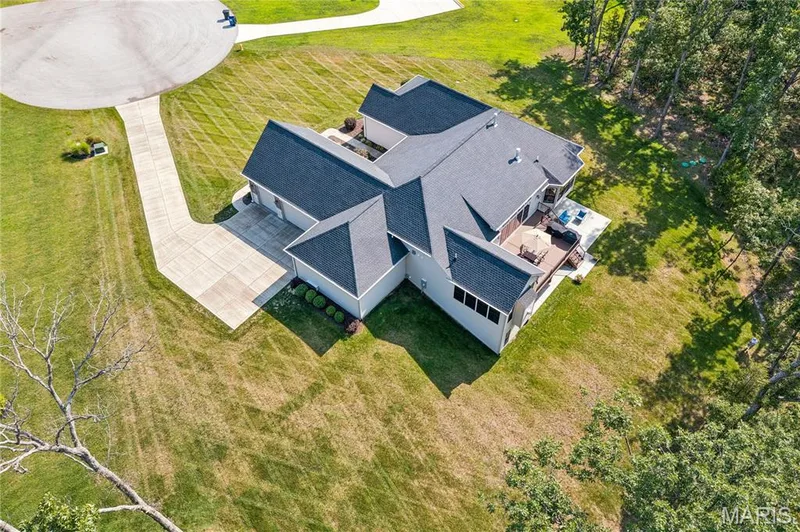 Expansive 3-acre property featuring a paved driveway, attached garage, and a multi-level deck — 5 Timberdel Place, Foristell, MO 63348