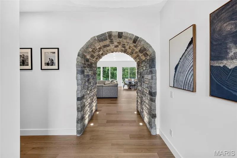 Distinctive arched stone passageway with rustic masonry detailing frames the entrance to this light-filled hallway — 3 Millers Court, O'Fallon, MO 63366