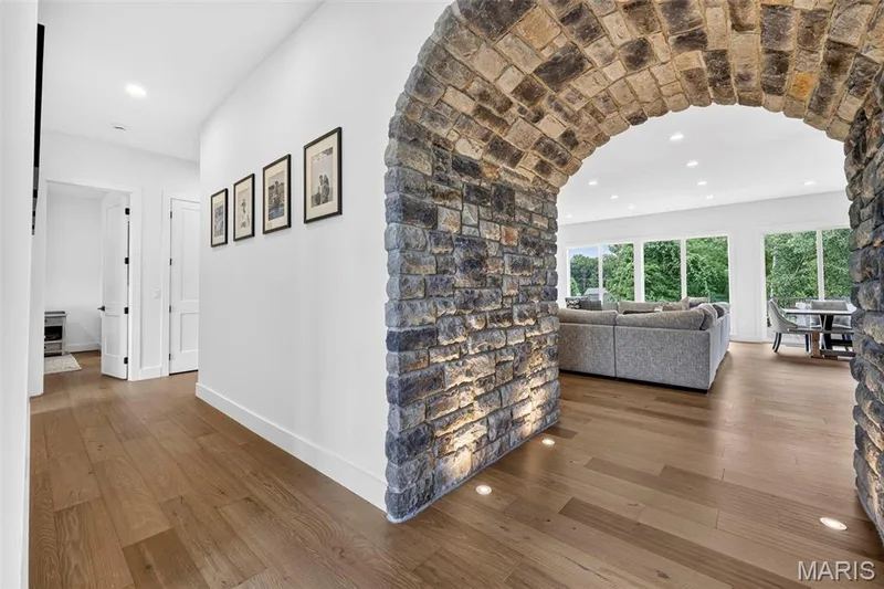 Striking architectural archway with hand-laid stone detailing frames the open living spaces — 3 Millers Court, O'Fallon, MO 63366