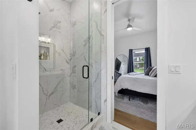 Glass-enclosed shower with a black-framed door, tile flooring, and a recessed niche — 3 Millers Court, O'Fallon, MO 63366