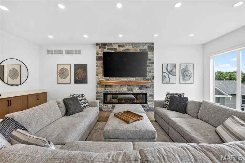 Stone-clad fireplace with an integrated linear electric insert and wood mantel — 3 Millers Court, O'Fallon, MO 63366