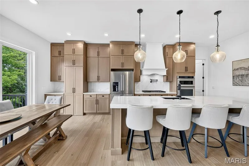 Well-appointed kitchen featuring light wood-finish cabinetry, stainless steel appliances, a center island with countertop seating, and recessed lighting — 3 Millers Court, O'Fallon, MO 63366