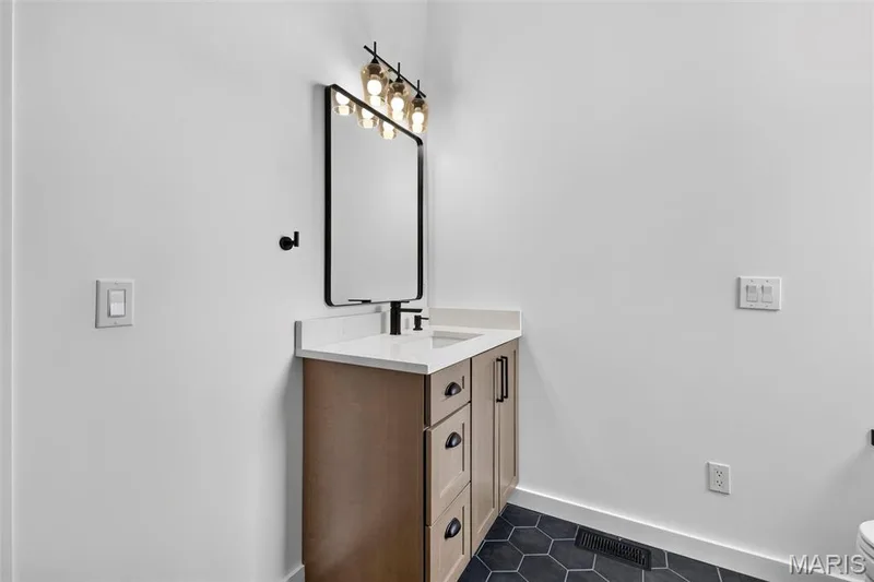 Wood-finish vanity with a white countertop and rectangular sink — 3 Millers Court, O'Fallon, MO 63366