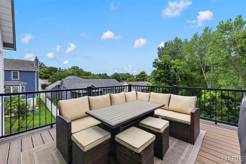 Elevated composite deck with black metal railing overlooking mature landscaping and neighboring properties — 3 Millers Court, O'Fallon, MO 63366