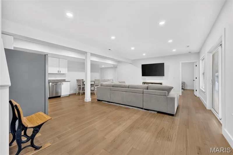 Recessed lighting throughout, wood-finish flooring, white cabinetry, stainless steel appliances, and sliding glass doors — 3 Millers Court, O'Fallon, MO 63366
