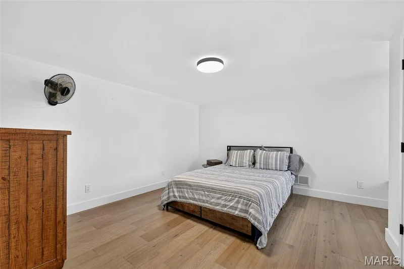 Bright bedroom featuring wood-finish flooring, recessed ceiling lighting, and ample natural light — 3 Millers Court, O'Fallon, MO 63366