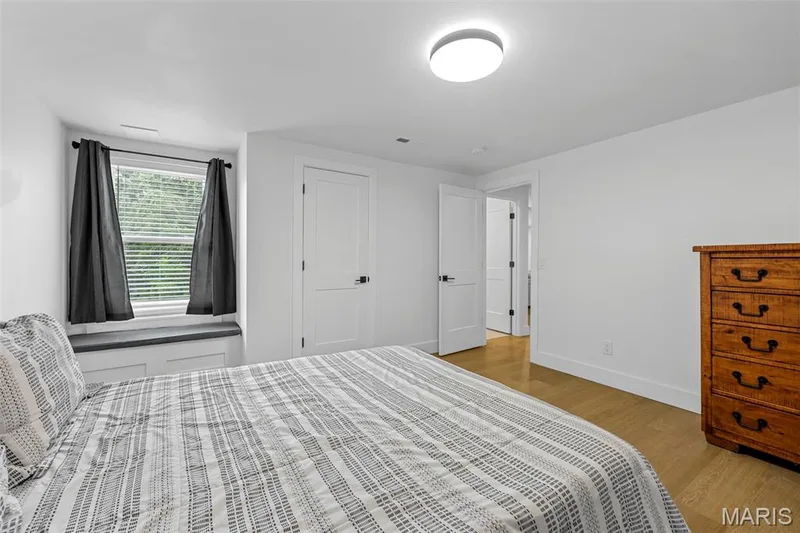 Window with a built-in seat, wood-finish flooring, white walls, and a ceiling-mounted light fixture — 3 Millers Court, O'Fallon, MO 63366