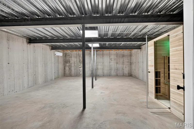 Spacious open floor plan with polished concrete flooring, exposed steel support beams, and corrugated metal ceiling with skylights providing natural illumination — 3 Millers Court, O'Fallon, MO 63366