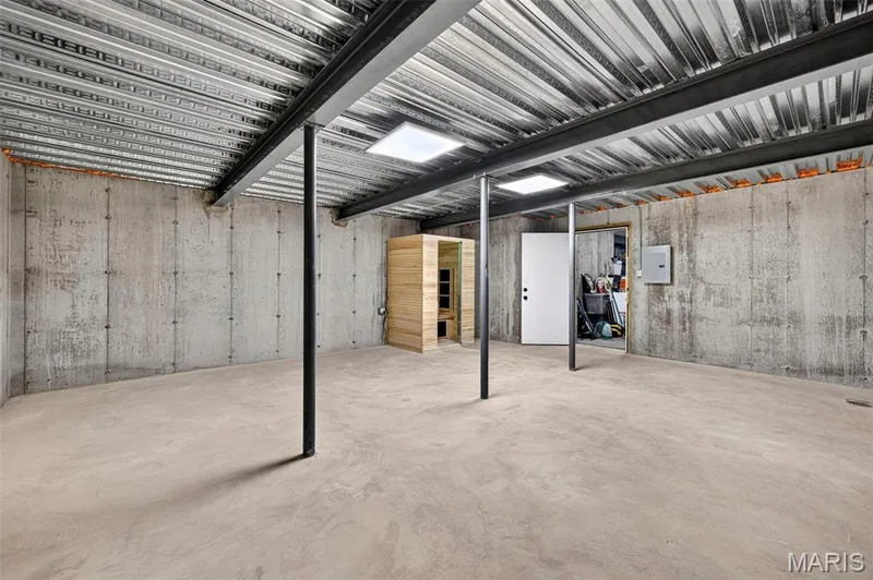Spacious industrial-style interior with polished concrete flooring, exposed structural steel columns, and corrugated metal ceiling with integrated skylights — 3 Millers Court, O'Fallon, MO 63366