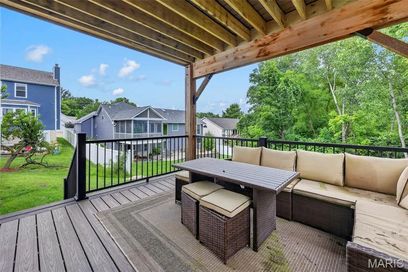 Covered deck with composite decking, black metal railings, and natural wood ceiling beams — 3 Millers Court, O'Fallon, MO 63366