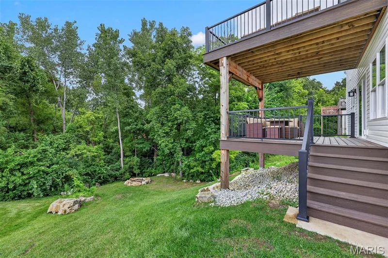 Multi-level deck with composite decking, metal railings, and a lower-level covered patio — 3 Millers Court, O'Fallon, MO 63366