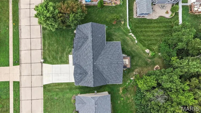 Aerial View of Contemporary Home with Dimensional Architectural RooflineThis residence showcases a striking multi-level roof design featuring dimensional peaks and clean geometric lines — 3 Millers Court, O'Fallon, MO 63366