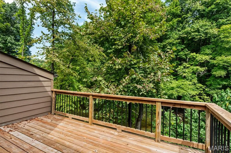 Step from the primary bedroom onto a tree-shaded balcony overlooking the lake — 35 Arrowhead Estates Court, Chesterfield, MO 63017