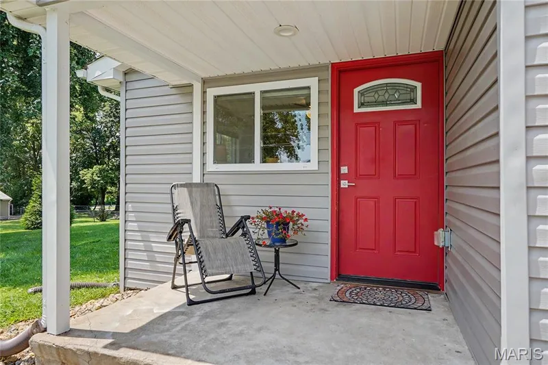 Covered front porch with concrete flooring and white support columns — 31 Plackemeier, O'Fallon, MO 63366