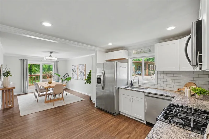 White kitchen cabinets with pantry left of refrigerator that stays — 31 Plackemeier, O'Fallon, MO 63366