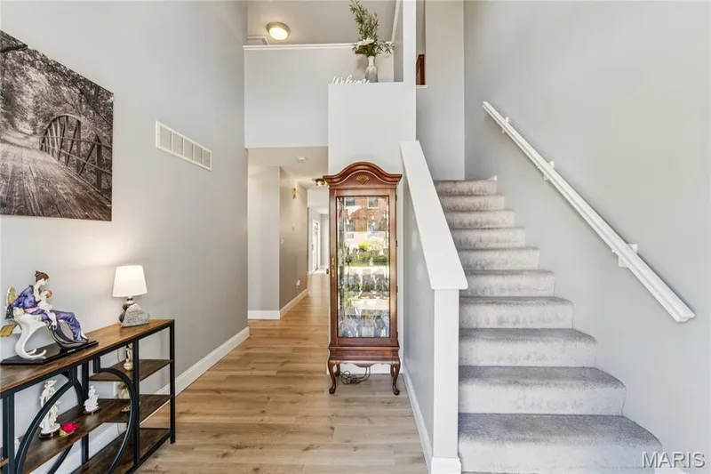 A bright, welcoming entry sets the tone for this spacious townhome, featuring soaring ceilings, beautiful flooring, and a clean, neutral palette that carries throughout the home. — 947 Rolling Thunder Drive, O'Fallon, MO 63368