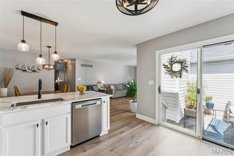 The open kitchen keeps you connected to the heart of the home, while sliding glass doors bring in natural light and provide easy access to the private outdoor space—perfect for relaxing or entertaining. — 947 Rolling Thunder Drive, O'Fallon, MO 63368