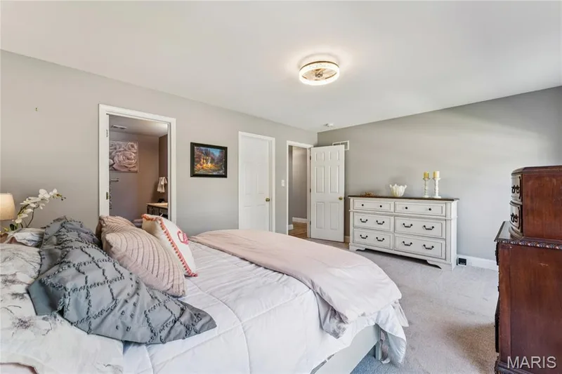The primary suite pairs everyday convenience with a private en-suite bath and ample room for substantial bedroom furniture. — 947 Rolling Thunder Drive, O'Fallon, MO 63368