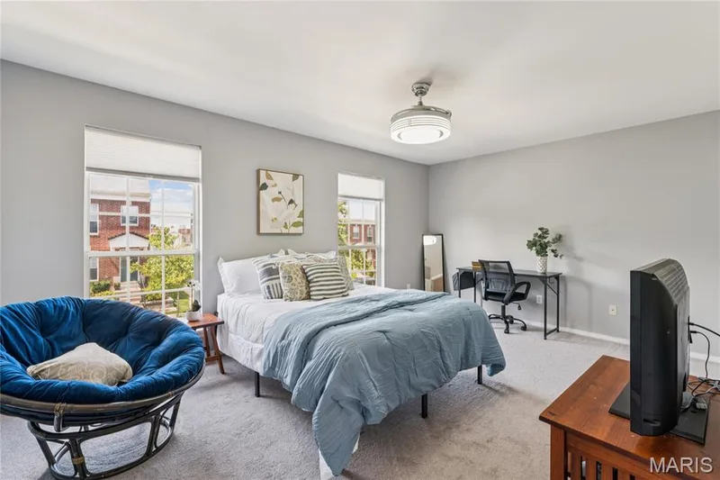 This upper-level bedroom offers a peaceful escape with ample space and the luxury of a walk-in closet, ensuring a clutter-free environment. The generous dimensions of the room provide a blank slate for any decor style, while the large windows draw in natural light to create a bright and airy haven. It's a perfect blend of comfort and convenience, ideal for relaxation and restful nights. — 947 Rolling Thunder Drive, O'Fallon, MO 63368