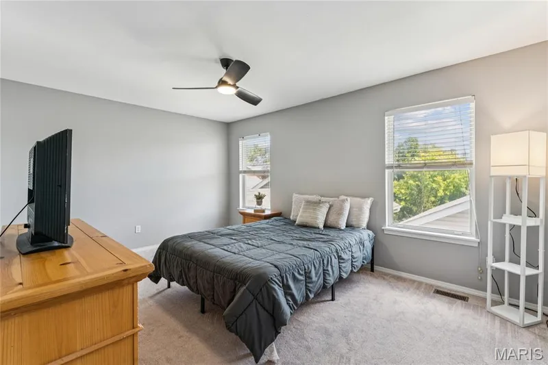 This second upper-level bedroom is a cozy retreat with ample natural light streaming through its windows. Offering the convenience of a walk-in closet, this space is not just a place to sleep but a personal sanctuary designed for comfort and organization. It's an ideal canvas for creating a private haven tailored to your taste and needs. — 947 Rolling Thunder Drive, O'Fallon, MO 63368
