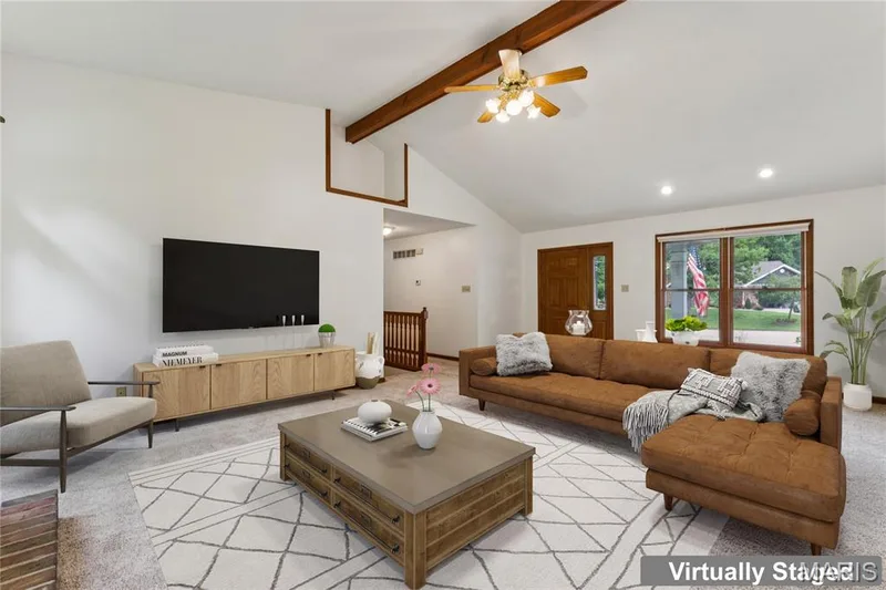 Vaulted ceilings, a brick fireplace, and arched windows framing the trees outside, this living room brings the whole home's character together in one space. — 416 Loiselaine Drive, O'Fallon, MO 63366
